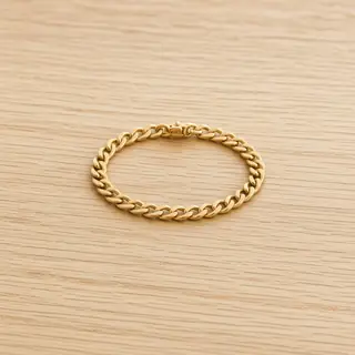 Gouden schakelarmband op eikenhout