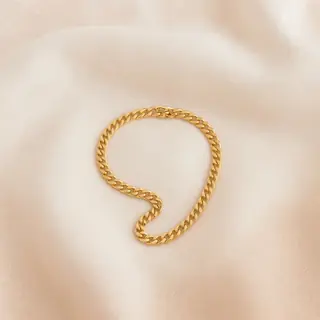 Gouden schakelketting, losjes gedrapeerd op linnen